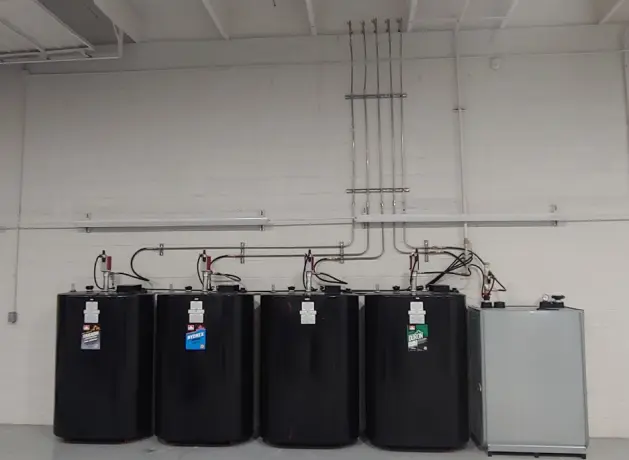 A row of black tanks sitting in a room.