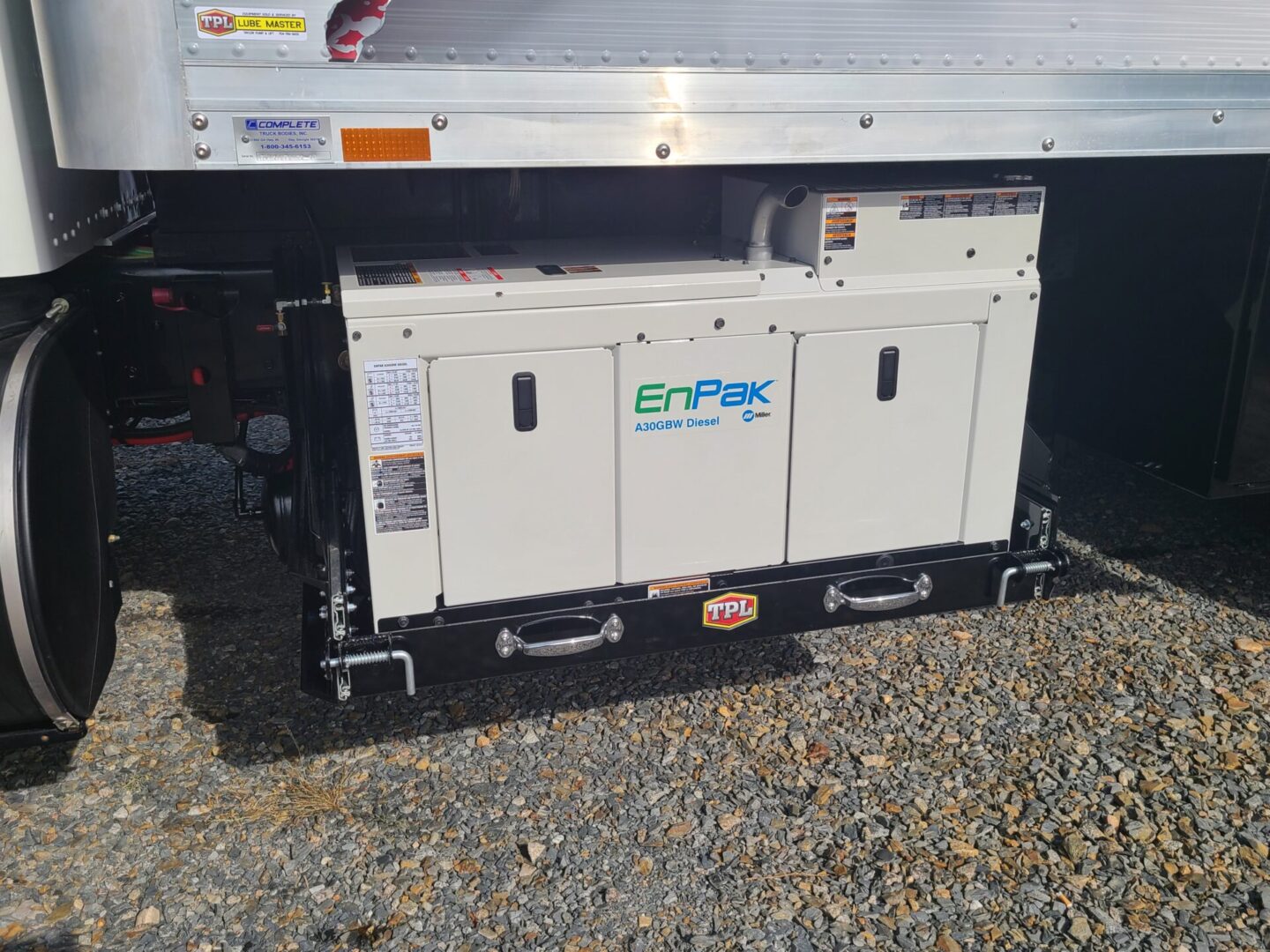 A large white truck with two generators on the side.