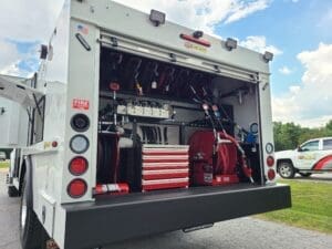 A truck with the back open and tools in it.