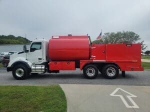 A red and white truck is parked on the side of the road.