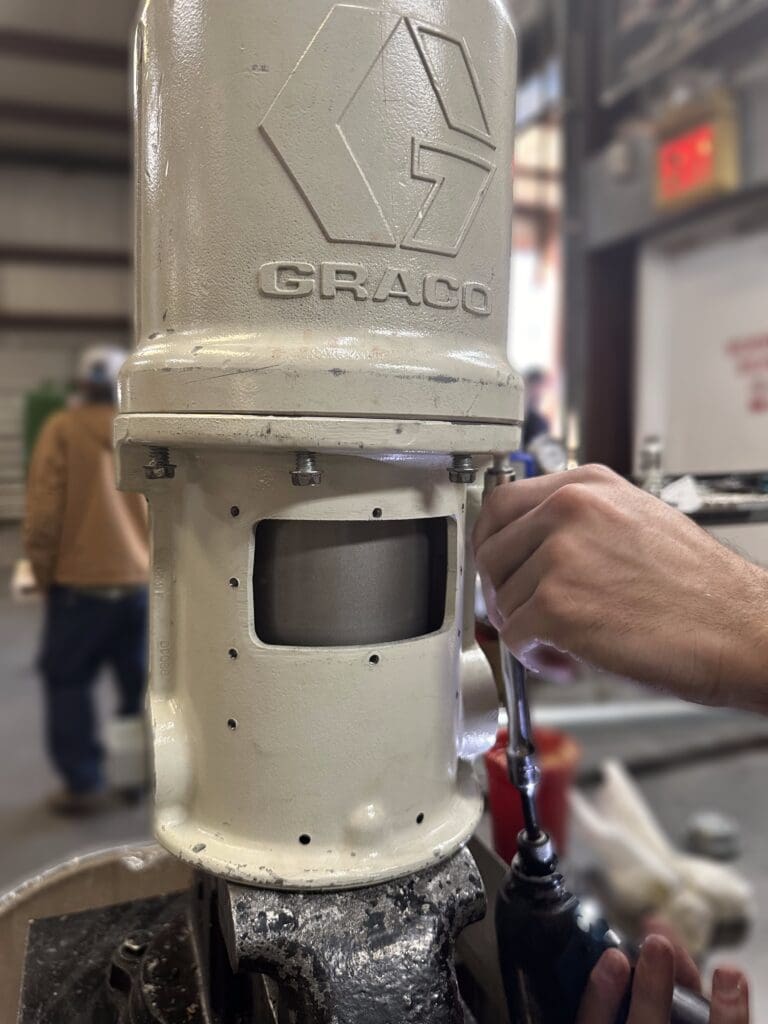 Side view of off-white Graco grease pump cylinder housing