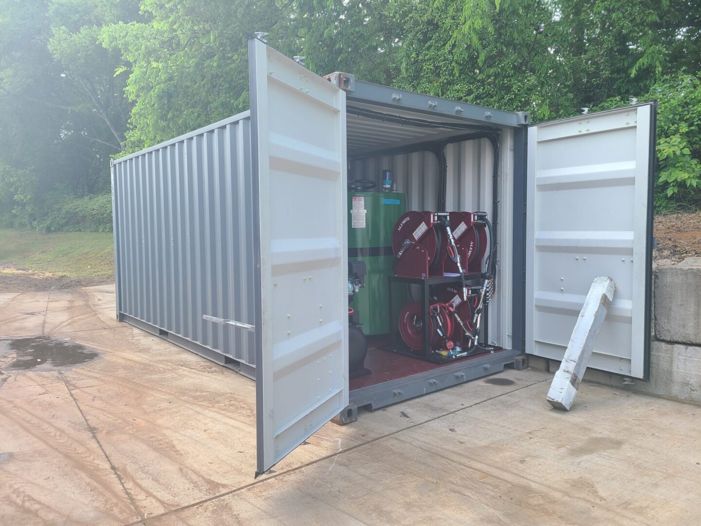 A container with two large doors open on the ground.