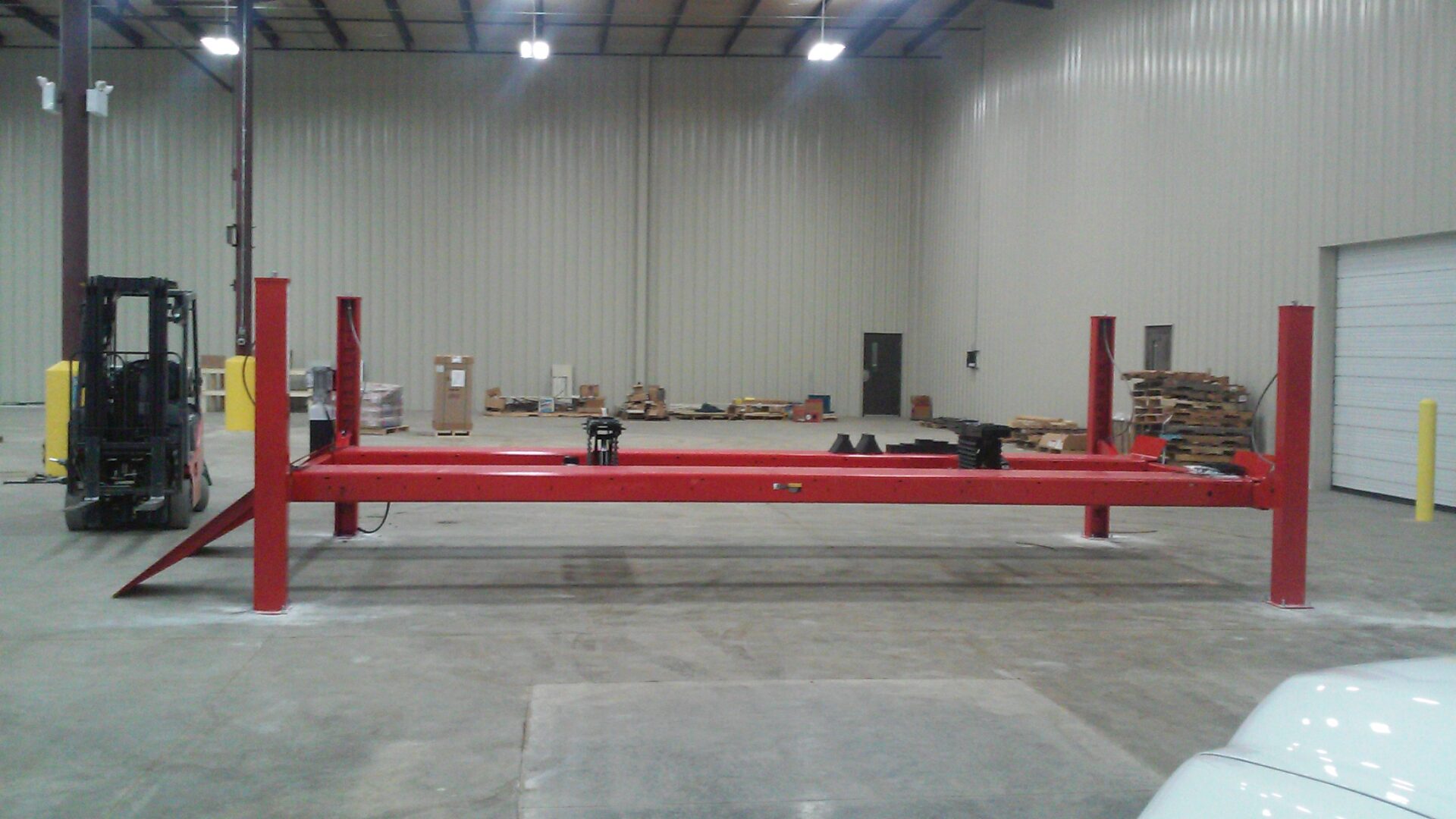 A red metal structure in an empty warehouse.