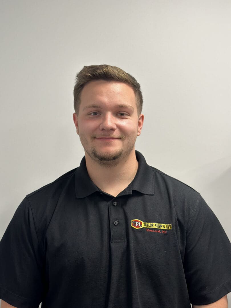 Man in black polo shirt, smiling.