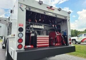 A truck with the back open and tools in it.