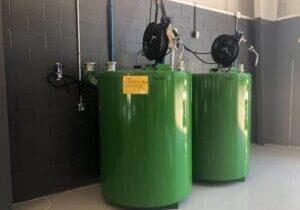 Bulk oil storage tanks with hose reels in a fleet shop fluid management system for faster lubricant dispensing and cleaner waste oil handling.